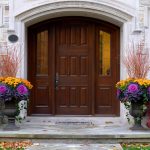 Colorful fall container garden with mums, ornamental cabbage, and pumpkins"